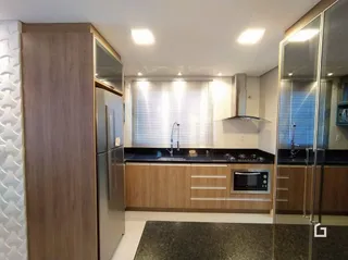 Foto de uma cozinha com armários de madeira e eletrodomésticos em aço inoxidável.