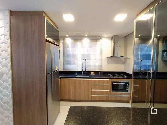Foto de uma cozinha com armários de madeira e eletrodomésticos em aço inoxidável.