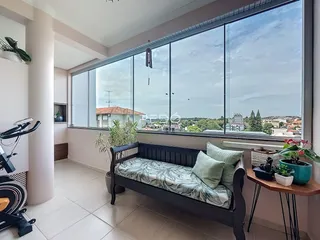 Quarto com grande janela de vista para a paisagem urbana.