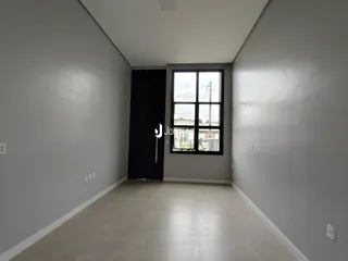 Hall de entrada com paredes brancas e piso claro.