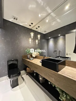 Foto de um banheiro moderno com bancada de madeira e pias pretas.