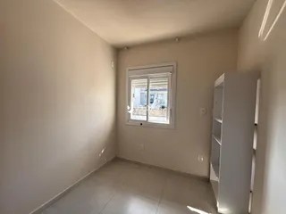 Foto de um cômodo interno com paredes claras e piso de cerâmica.