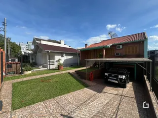 Fachada de uma casa em Lajeado, Brasil com jardim e área de garagem.