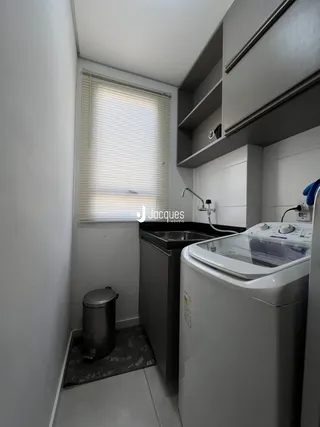 Foto de uma cozinha estreita com máquina de lavar roupa e janela.