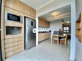 Cozinha moderna com armários de madeira e eletrodomésticos em aço inoxidável.