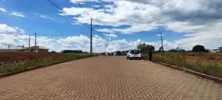 Vista de uma estrada pavimentada em uma área com vegetação seca.