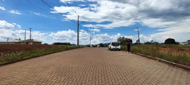 Vista de uma estrada pavimentada em uma área com vegetação seca.
