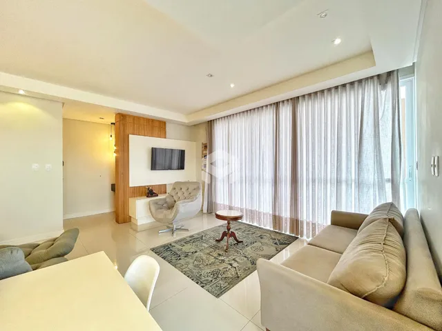 Sala de estar moderna com sofá e decoração clara.
