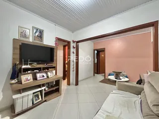 Sala de estar com parede em tom de rosa e piso claro.