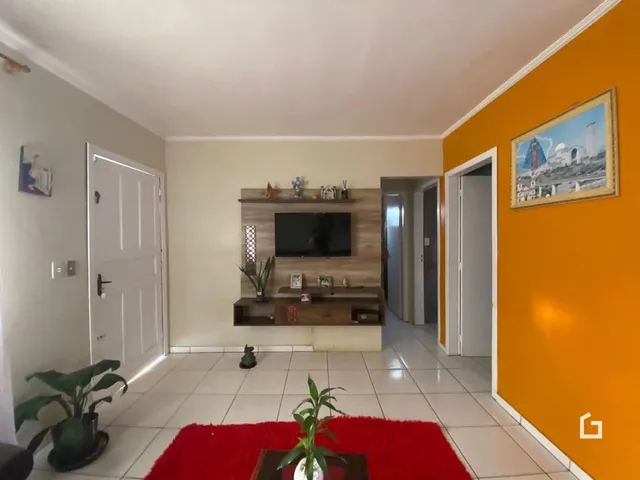 Sala de estar com parede laranja e piso de cerâmica.