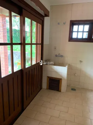 Vista interna de uma sala com portas de madeira e piso de cerâmica.