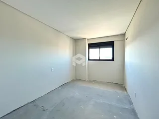 Foto de um cômodo vazio com paredes brancas e piso de concreto.