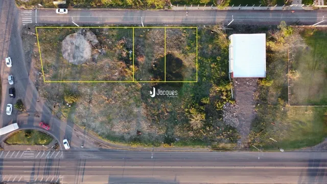 Vista aérea de um terreno com área gramada e uma construção lateral em Lajeado.