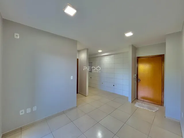 Hall de entrada de uma residência com piso de cerâmica clara.