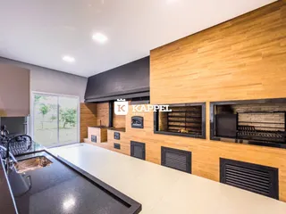 Cozinha moderna com bancada escura e piso claro, com acesso a área externa.