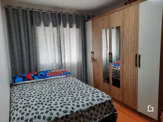 Quarto com cama e armário de madeira em um imóvel no Brasil.