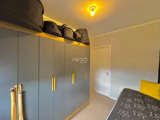 Quarto com armários embutidos e cabeceira de cama.