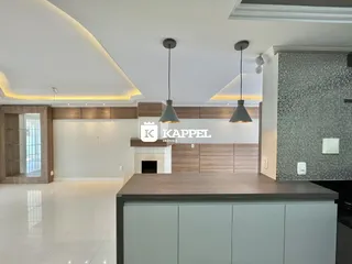 Esta é uma cozinha moderna com armários de madeira e iluminação embutida.