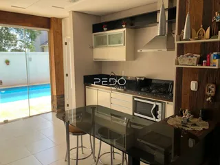 Vista da cozinha e sala de estar com acesso a uma área externa e piscina.