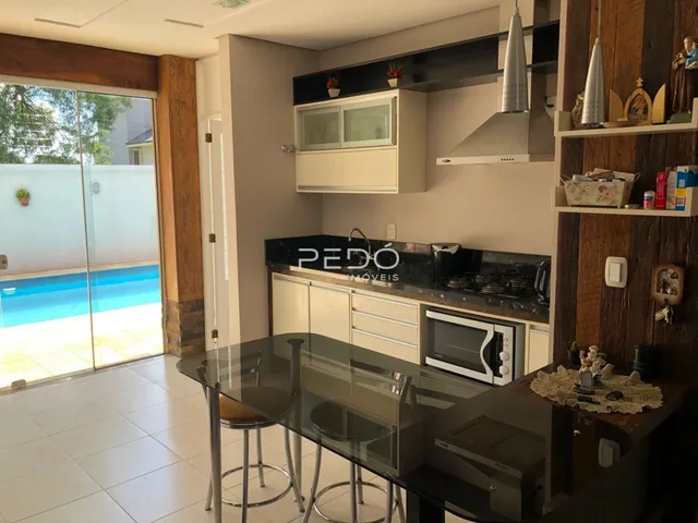 Vista da cozinha e sala de estar com acesso a uma área externa e piscina.