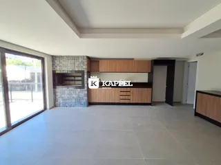 Sala de estar com armários de madeira e piso claro.