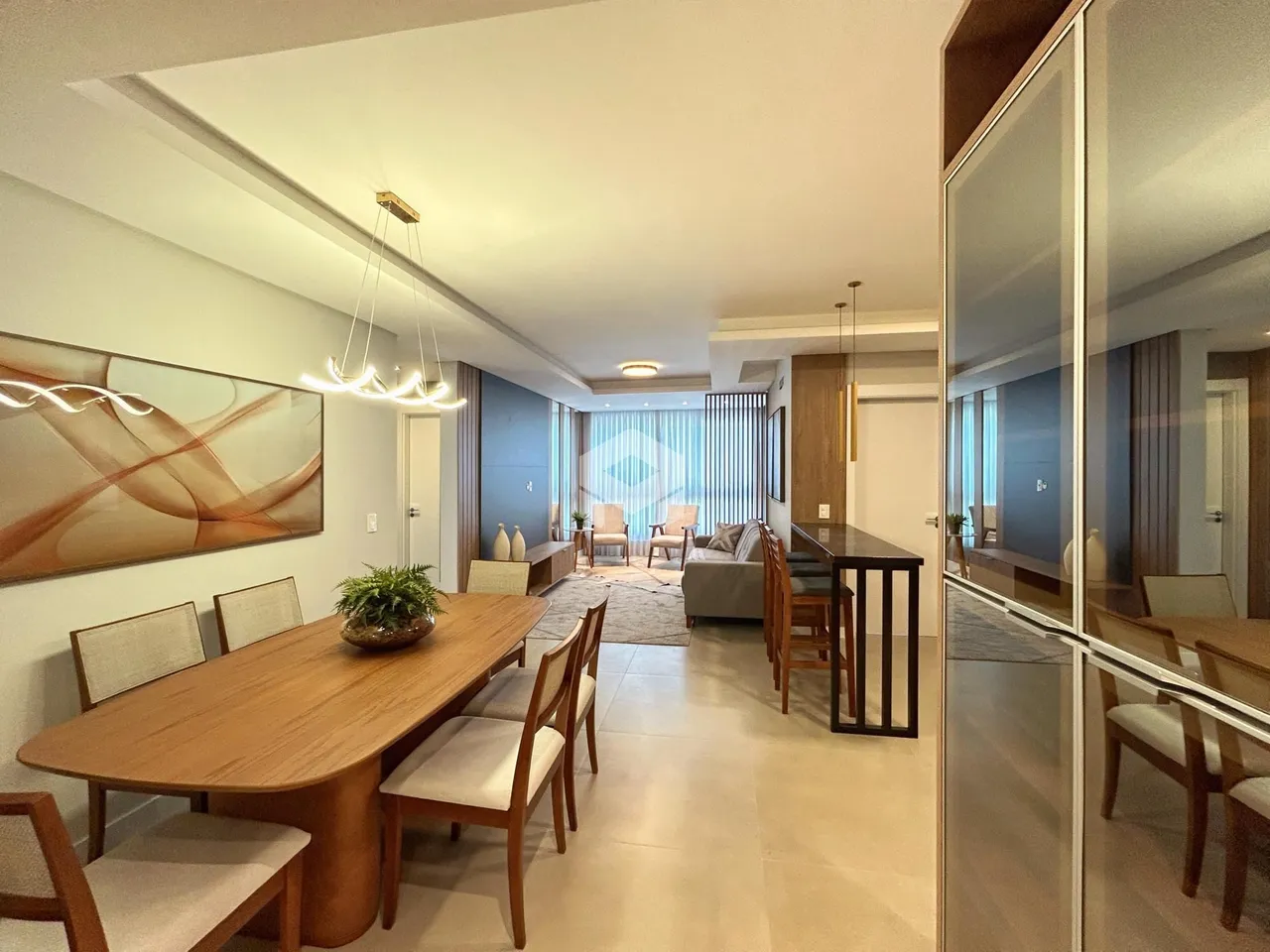 Uma sala de estar e jantar moderna com piso claro e móveis de madeira.