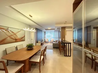 Uma sala de estar e jantar moderna com piso claro e móveis de madeira.