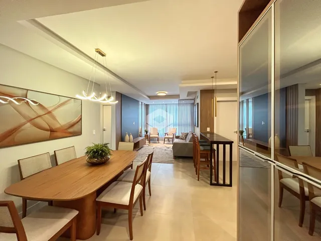 Uma sala de estar e jantar moderna com piso claro e móveis de madeira.