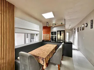 Ambiente interno de uma sala de estar com cozinha integrada em Lajeado.