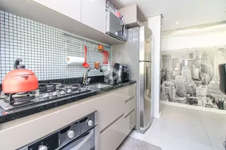 Cozinha moderna com armários brancos e bancada escura.