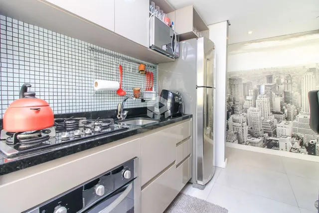 Cozinha moderna com armários brancos e bancada escura.