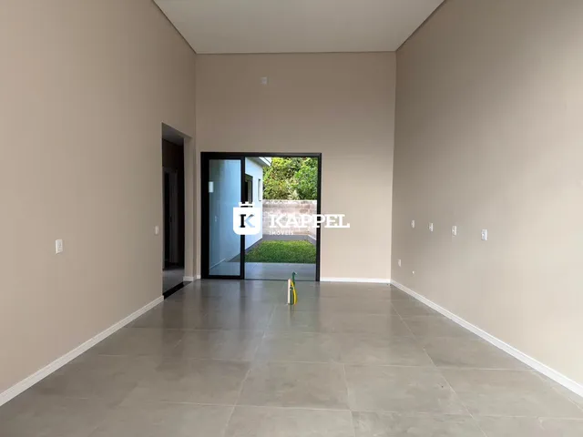Hall de entrada com piso de porcelanato e acesso a um jardim externo.