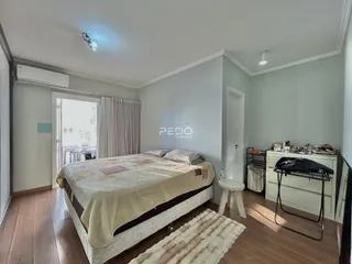 Quarto com cama e piso de madeira no imóvel.