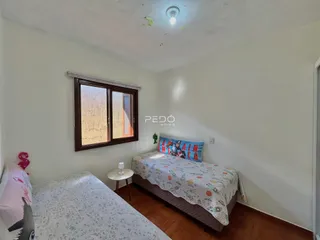 Quarto com cama e janela de madeira em um imóvel.