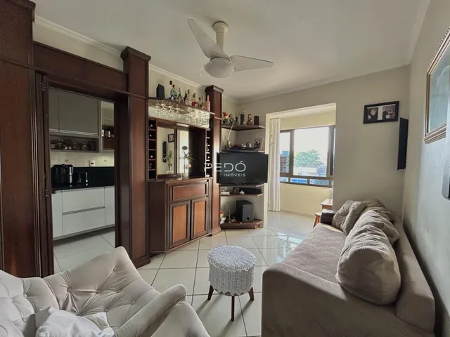 Sala de estar com móveis de madeira e sofá claro.