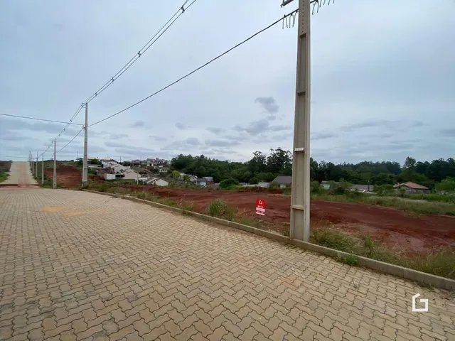 Vista da rua e propriedade em Lajeado, Brasil, com terreno de terra e postes de luz.