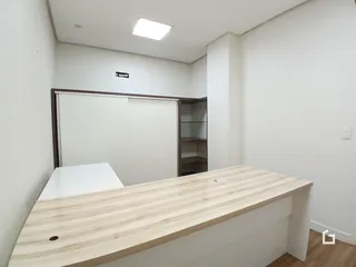 Interior de um cômodo com paredes brancas e armários de madeira.
