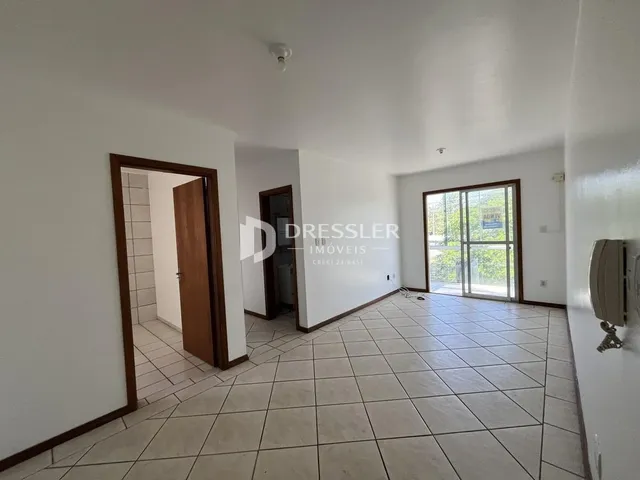 Interior de uma sala com piso de cerâmica e paredes brancas.