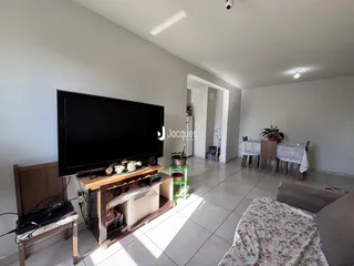 Sala de estar com televisão e móveis de madeira.