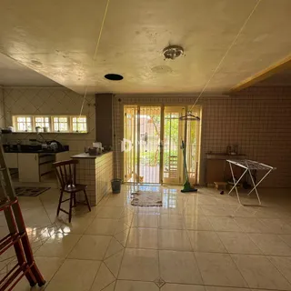 Ambiente interno de uma sala de estar com acesso a uma área externa através de portas de vidro.