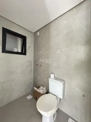 Foto de um banheiro com revestimento de azulejo claro.