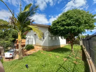 Fachada de uma residência com gramado e vegetação.