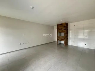 Sala de estar ampla com piso de cerâmica e parede de madeira em um imóvel.