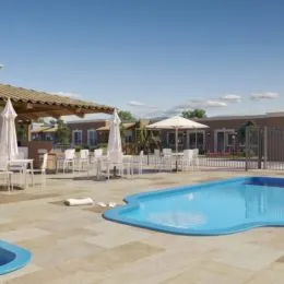 Foto de uma piscina externa com deck e área verde em uma propriedade.