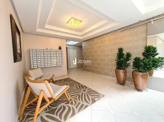 Sala de estar com piso claro e parede texturizada.