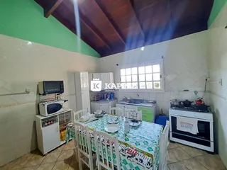 Foto de uma sala de jantar com mesa e área de cozinha em um imóvel.