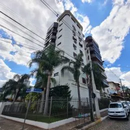 Fachada de um prédio residencial em Lajeado, Brasil com árvores ao redor.