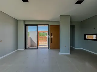 Sala de estar com piso claro e porta de vidro que dá acesso ao exterior.