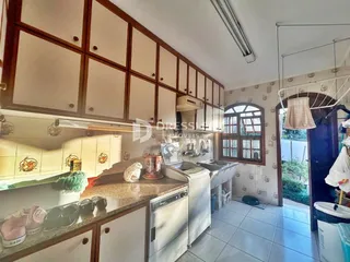 Cozinha com armários de madeira e bancada clara.