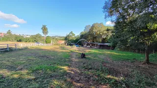 Vista de um terreno gramado com cerca e vegetação na propriedade.